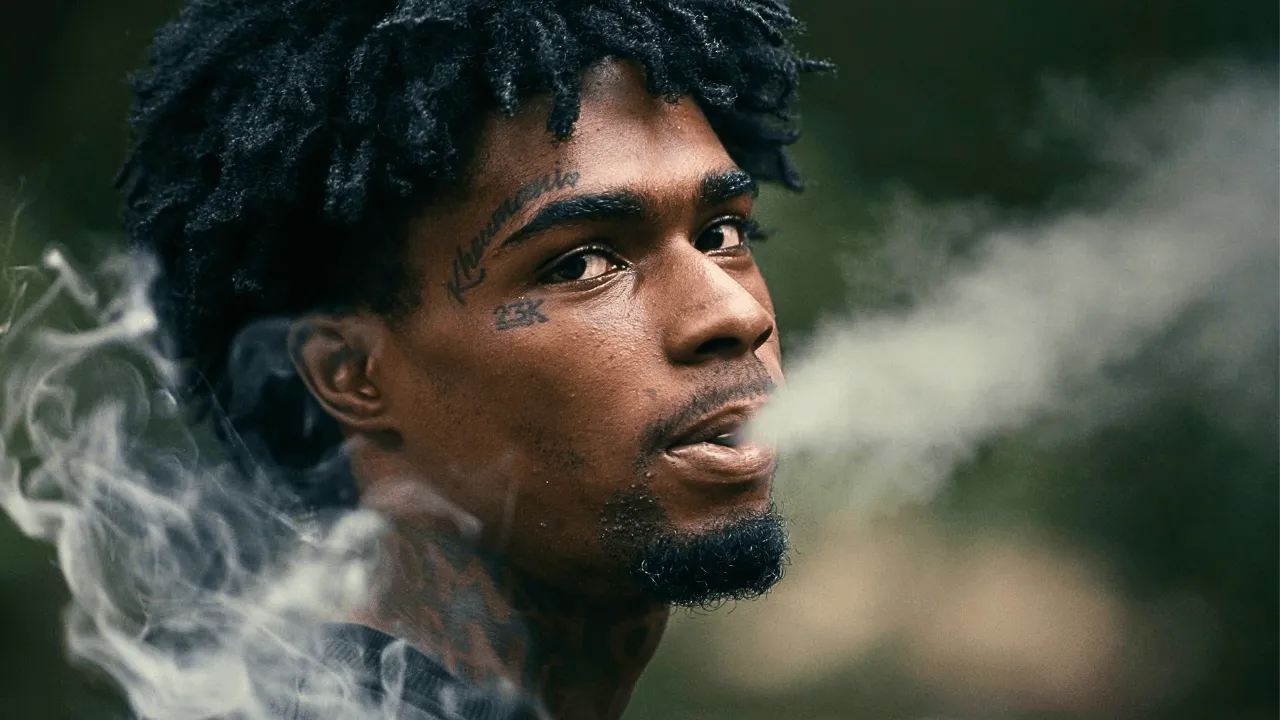 Young man exhaling smoke in a dramatic close-up portrait, from The Taboo Room documentary series.