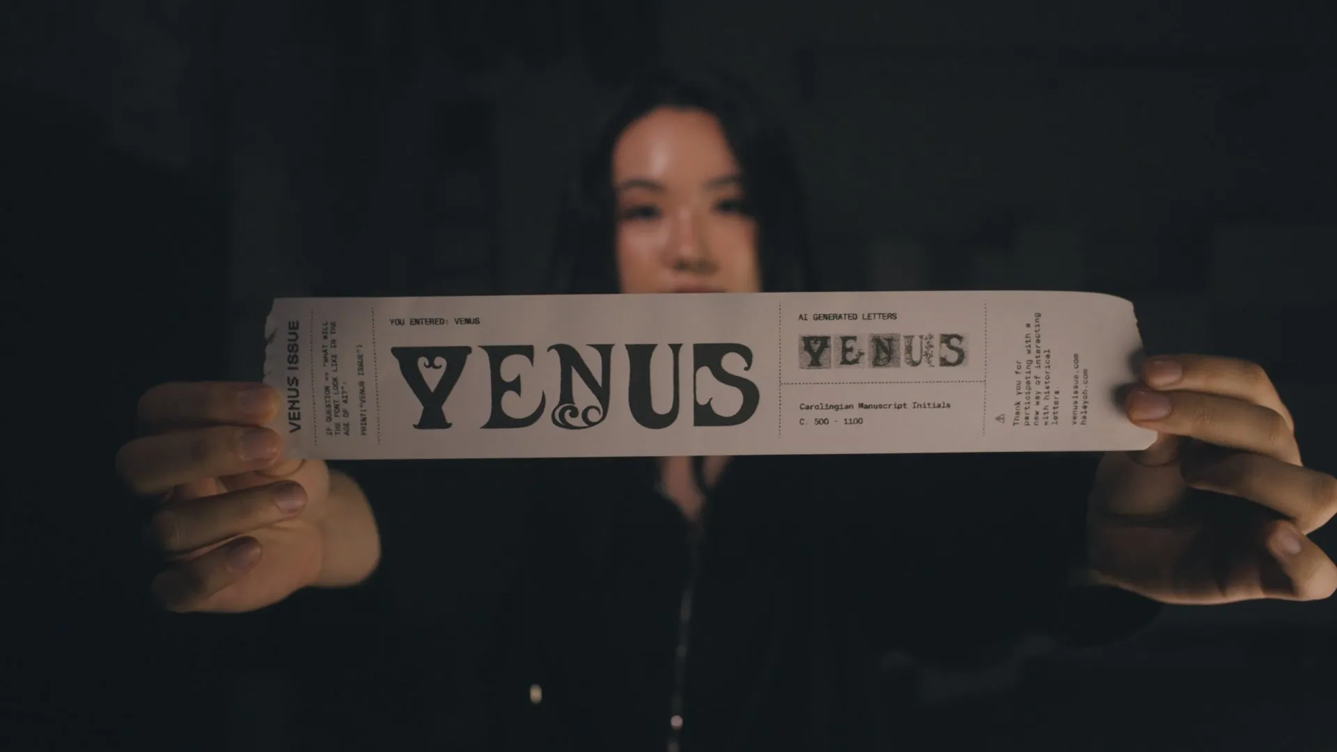 Woman holding up a printed Venus Issue strip toward the camera.